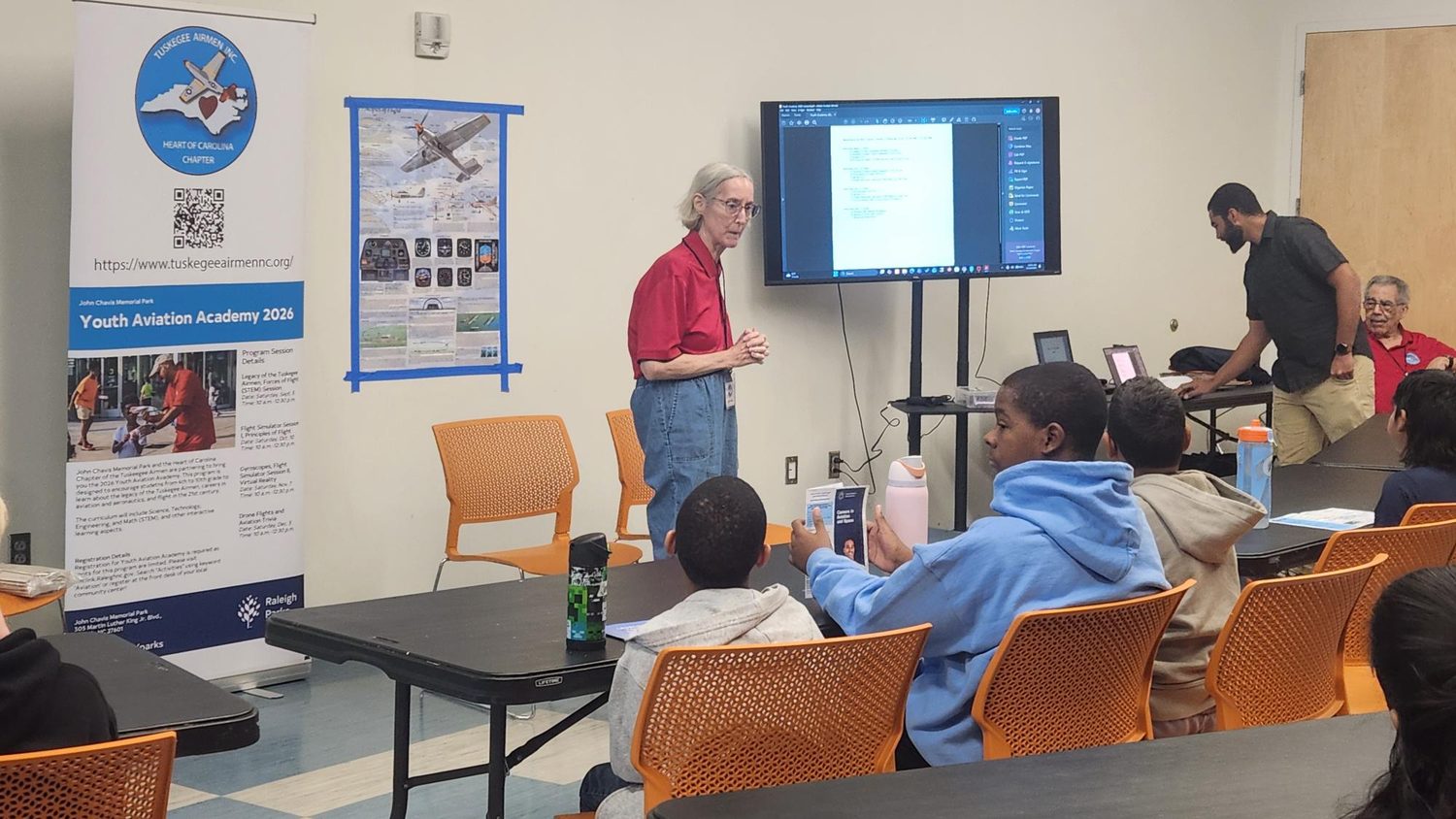 A chapter volunteer presents the day's program to seated students